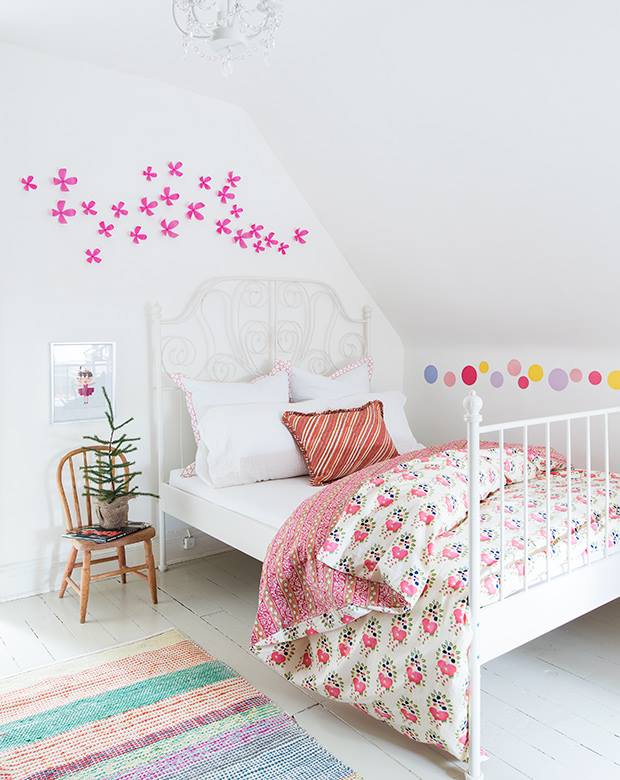 Một cây thông Giáng Sinh mini đặt ở đầu giường cùng với giấy dán trang trí tường theo phong cách năng động sẽ mang không khí lễ hội vào phòng của các bé.
