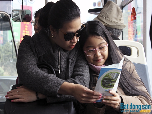 Hai mẹ con một hành khách thích thú tìm hiểu những thông tin về tuyến xe buýt nhanh BRT.