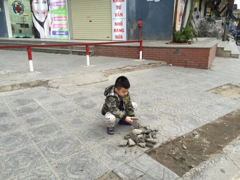 Trẻ em chơi mảnh vỡ trên vỉa hè quanh khu dân cư
