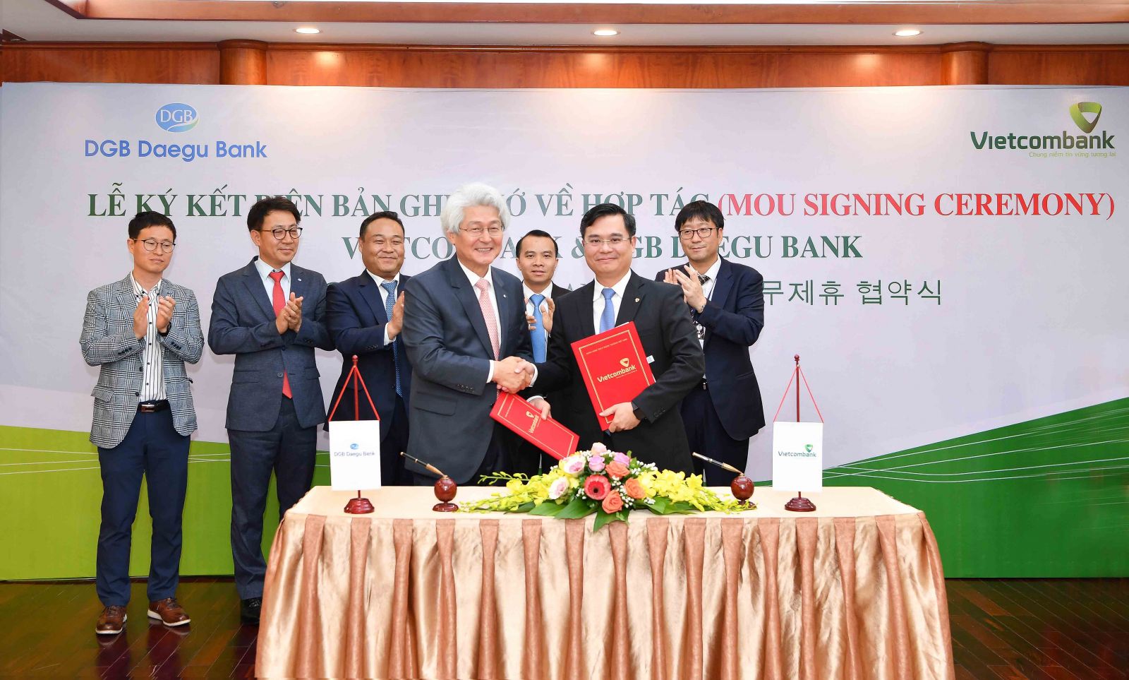 Ông Nguyễn Thanh Tùng – Phó Tổng Giám đốc Vietcombank (hàng đầu, bên phải) và ông Kim Tae-oh – Chủ tịch Hội đồng quản trị kiêm Tổng Giám đốc Tập đoàn DGB Financial Group, kiêm Tổng Giám đốc Ngân hàng DGB Daegu Bank đại diện 2 bên ký kết biên bản ghi nhớ