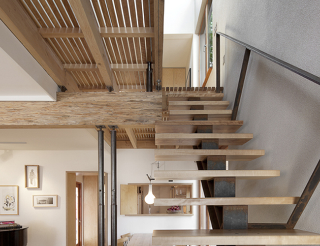 Cầu thang được thiết kế với phần tay vịn tối giản, chủ yếu sử dụng màu nâu gỗ hài hòa với tông tường trắng.