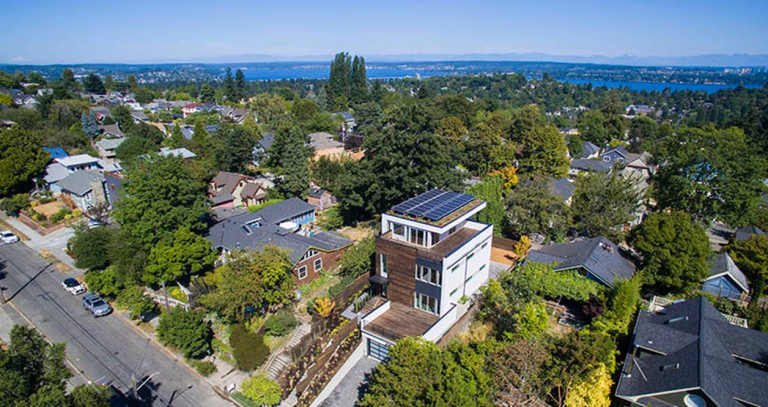 Nhìn từ xa, ngôi nhà thực sự khác biệt với các ngôi nhà khác trong khu vực. Việc sử dụng những tấm năng lượng mặt trời và cây xanh trên mái là một thiết kế độc đáo, tạo không gian sống hiện tại, đương thời.