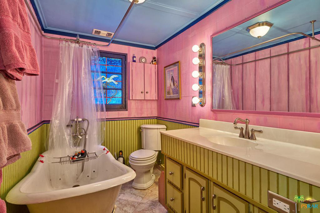 Phòng tắm lớn được sơn màu hồng, có bồn rửa lớn và bồn tắm đứng.