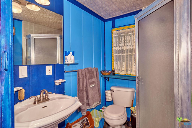 Phòng tắm nhỏ được sơn màu xanh da trời.