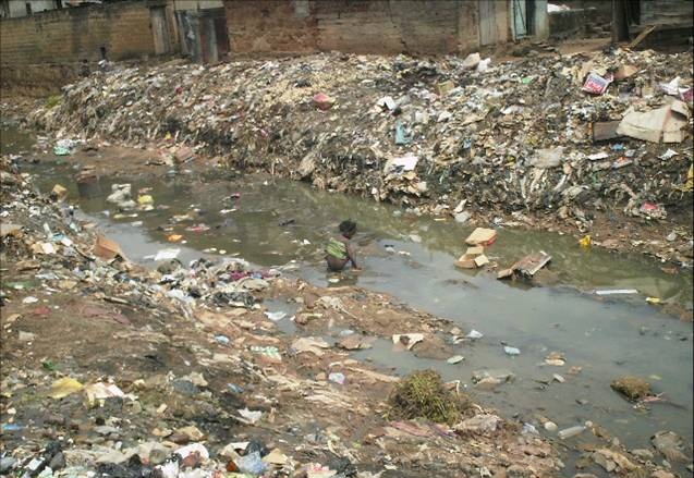 Một trẻ em đi vệ sinh ngay giữa dòng nước thải bẩn thỉu ở Nigeria. Ảnh: Wikipedia