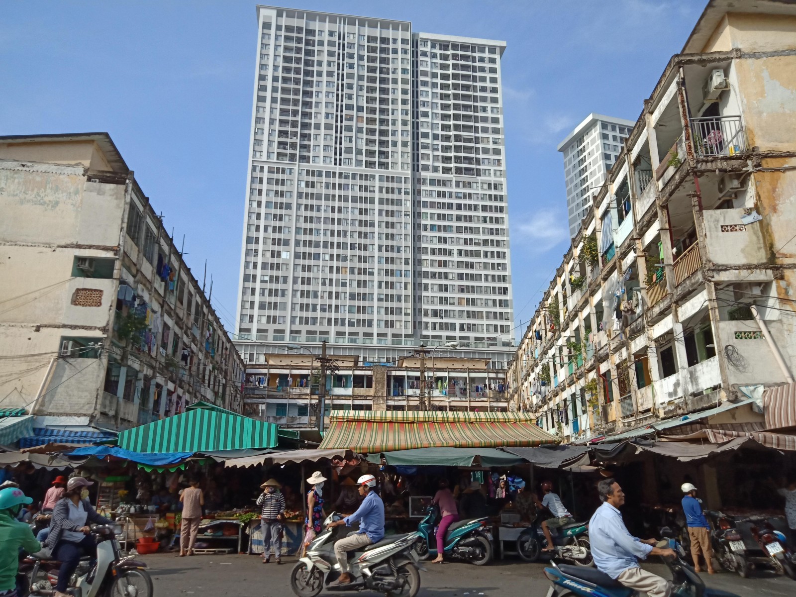 Chung cư sau nhiều năm trở nên nhếch nhác, bọc giữa chợ Nguyễn Hữu Hào đã tồn tại từ lâu. Xung quanh, nhiều chung cư cao tầng được xây dựng mới khang trang. Ảnh: Thu Thanh.