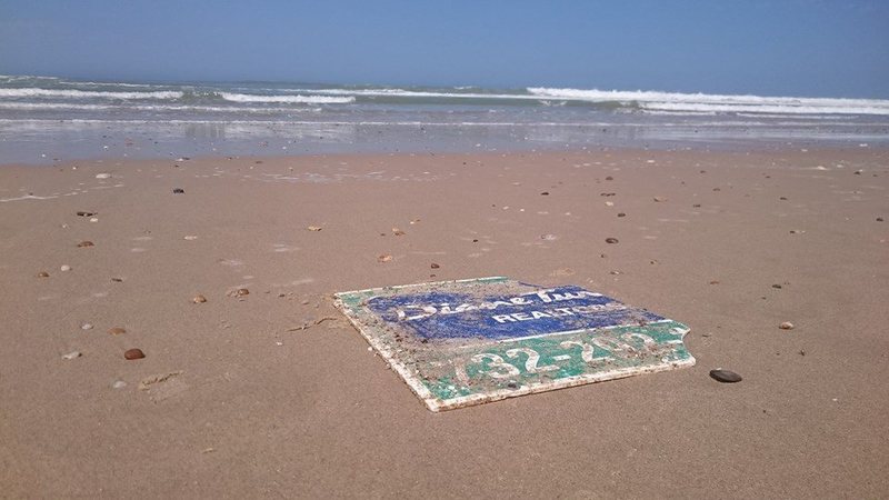 Một nửa tấm biển nằm trên mặt cát