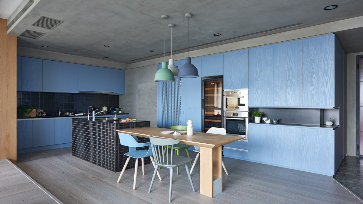 Tông màu xanh dương nhẹ được phủ lấp từ chiếc đèn trang trí, những chiếc ghế ăn đến tủ bếp.