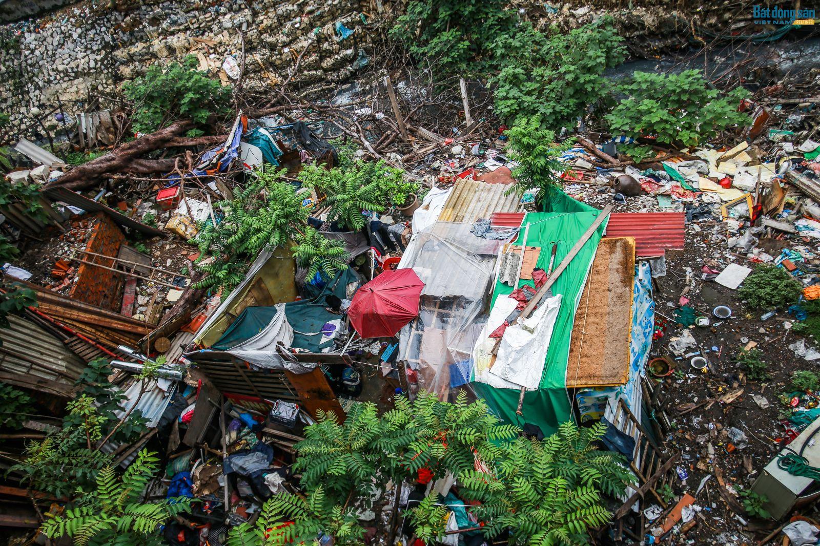 Dưới chân cầu Long Biên, nhiều loại rác được tập kết: bao ni lông, gỗ, hoa quả thối,...