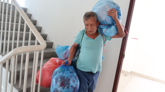 Ông Trần Quang Huệ mang hành lý ra khỏi chung cư