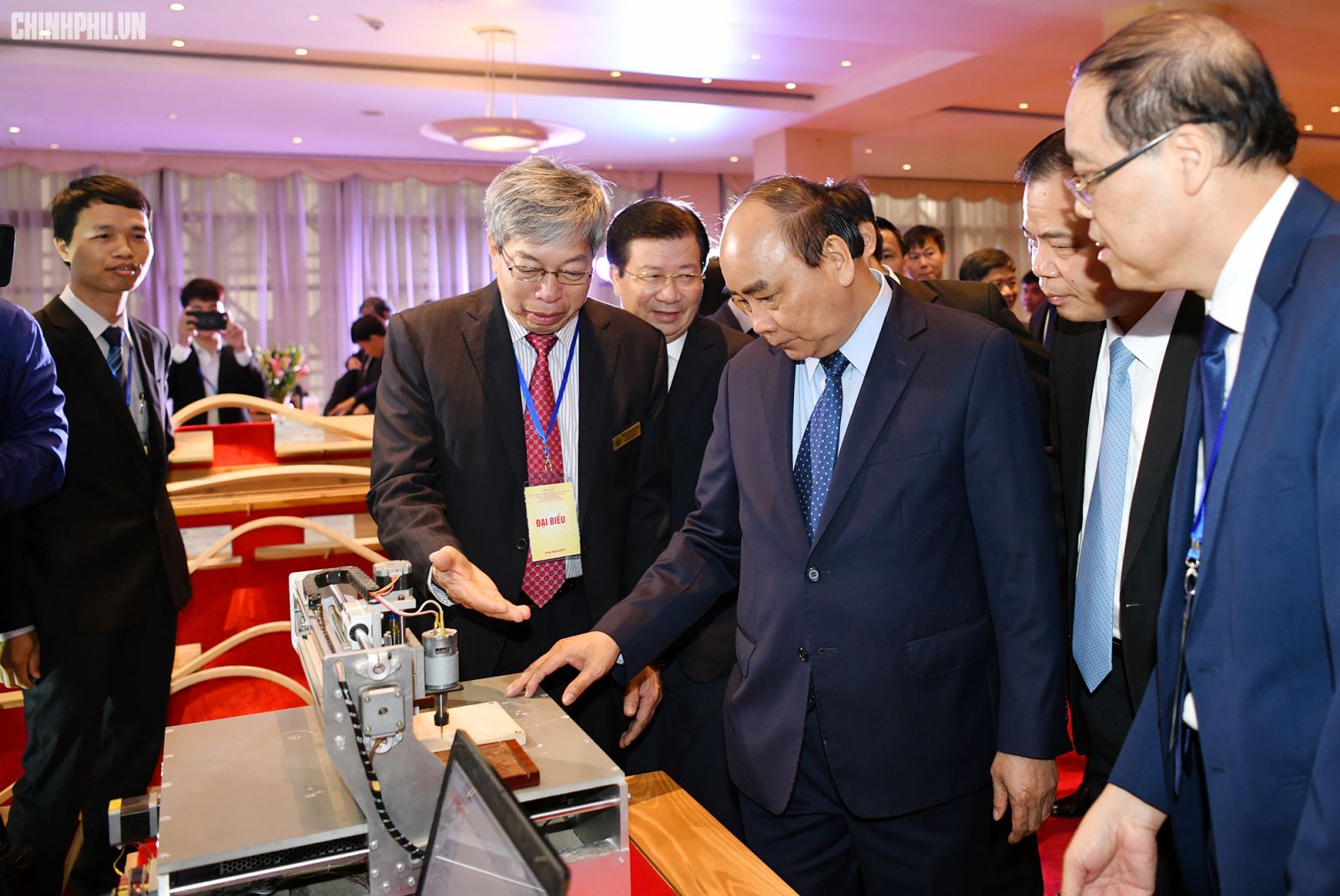 Thủ tướng nghe đại diện một doanh nghiệp giới thiệu thiết bị chế biến gỗ. Ảnh: VGP/Quang Hiếu 