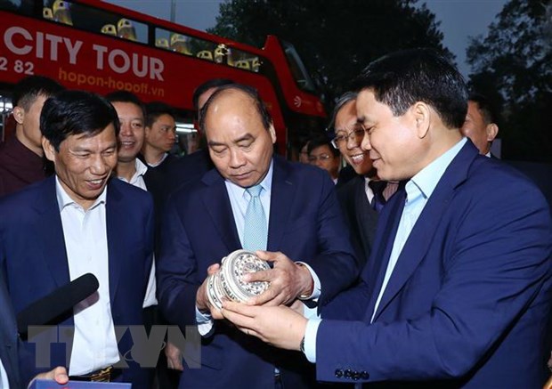Thủ tướng Nguyễn Xuân Phúc kiểm tra tặng phẩm cho báo chí vào chiều muộn ngày 24/2. (Ảnh: Thống Nhất/TTXVN)