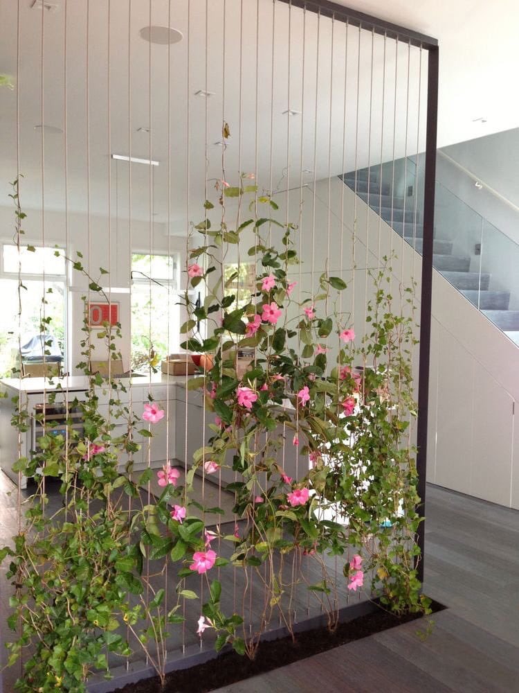 Không gian bếp và phòng khách được ngăn cách bởi “bức tường xanh” điểm những bông hoa xinh xắn.