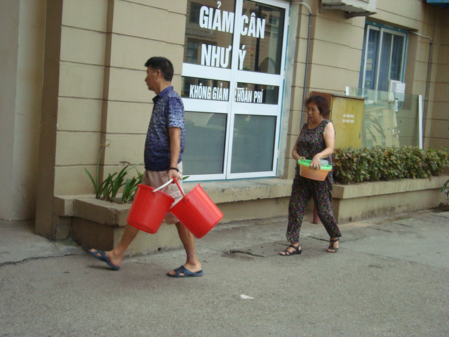 Người dân khu đô thị Mỹ Đình xếp hàng đi xách nước (Nguồn:Gia đình và xã hội).