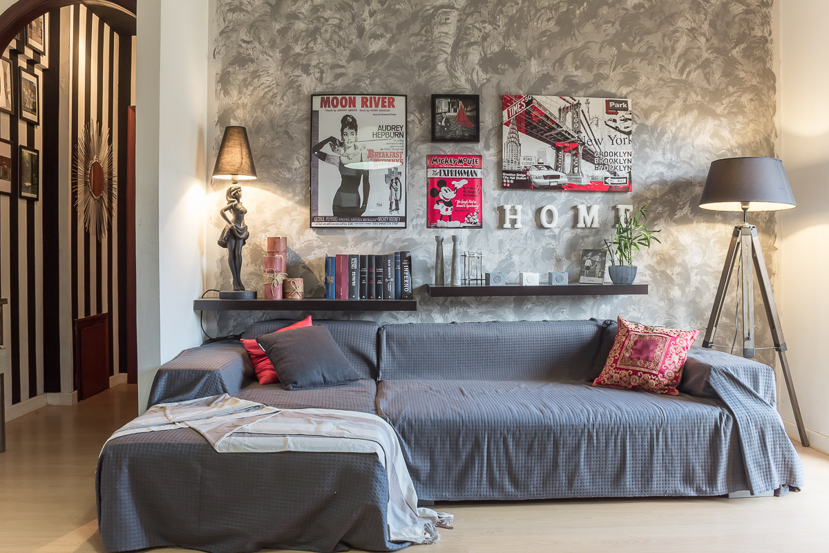 Phòng khách nhỏ với bức tường họa tiết phông nền và một chiếc ghế dài nhỏ màu xám tạo ra nét phá cách và mới mẻ.