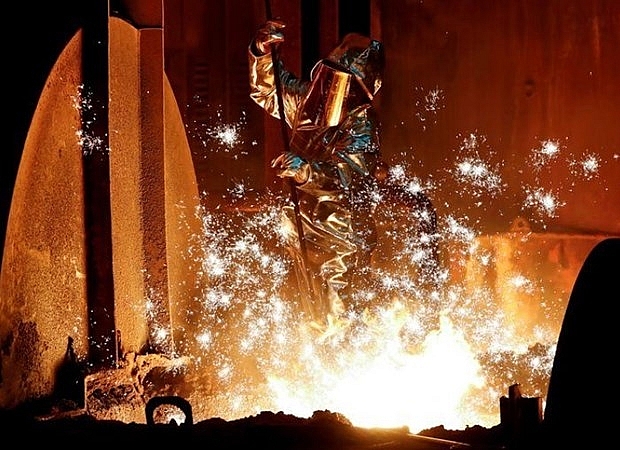 Một công nhân của tập đoàn công nghiệp Đức ThyssenKrupp AG lấy mẫu sắt thô từ lò cao tại nhà máy thép lớn nhất của Đức ở Duisburg
