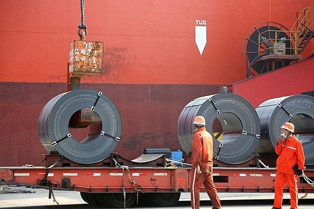 Công nhân bốc các sản phẩm thép xuất khẩu lên tàu chở hàng