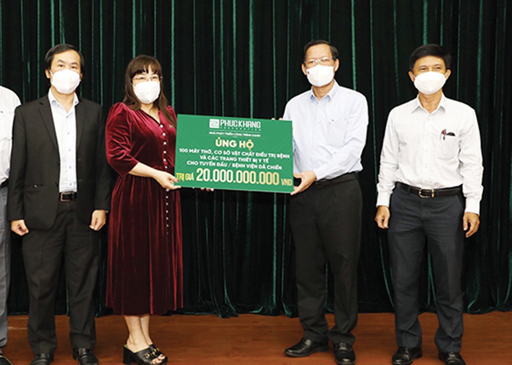 Bà Lưu Thị Thanh Mẫu, Tổng Giám đốc Phuc Khang Corporation trao bảng tượng trưng ủng hộ 20 tỷ cho ông Phan Văn Mãi, Chủ tịch UB NDTP, đồng hành cùng TP chống dịch.