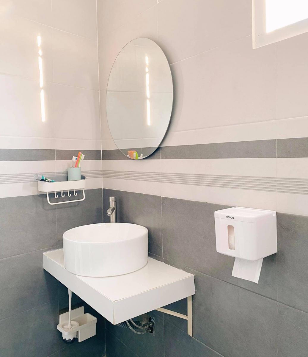 Phòng vệ sinh được thiết kế với tông màu trắng và xám mang lại cảm giác sạch sẽ. 