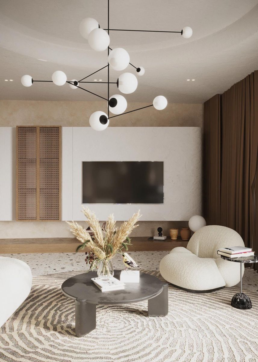 Phòng khách được thiết kế đơn giản với bộ sofa màu trắng, đèn chùm màu trắng và không thể thiếu tivi treo tường.