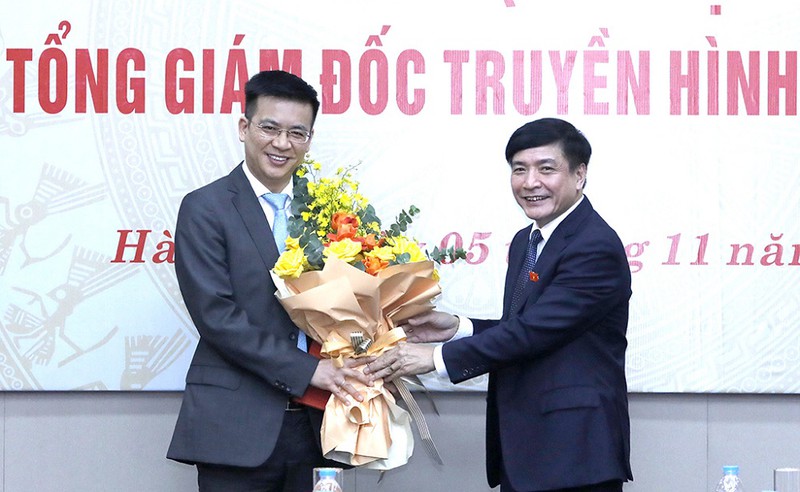 Tổng Thư ký Quốc hội Bùi Văn Cường (bên phải) tặng hoa chúc mừng tân Tổng giám đốc Truyền hình Quốc hội Việt Nam Lê Quang Minh.