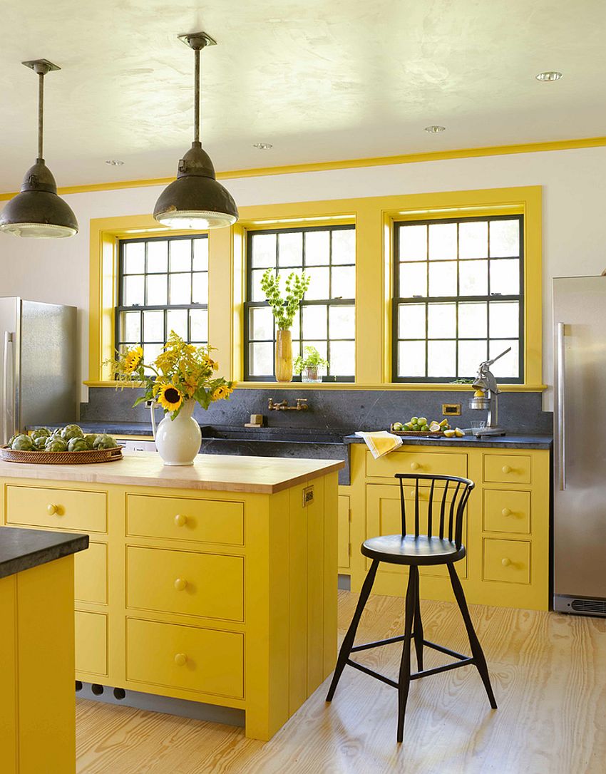 Đảo bếp và hệ tủ, khung cửa sổ đều được kết nối khéo léo bằng màu vàng của nắng.