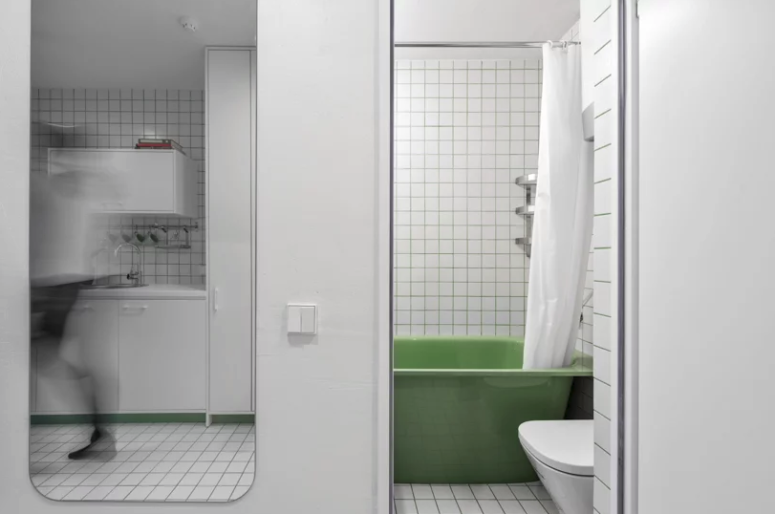 Phòng tắm nhỏ với bồn tắm màu xanh lá.