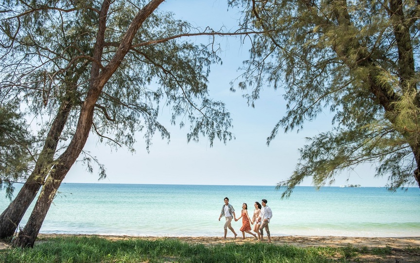 A group of people walking on a beach  Description automatically generated